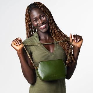 Model is wearing a green dress an the Coneli Fanny Pack - Edition Green with the extra accessory Golden Chain Green