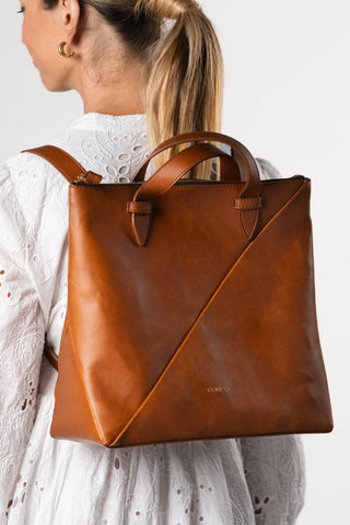 Model wearing the Coneli Tote as back pack in color camel