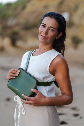 Model is posting on beach with the Fanny Pack Green as a cross-over bag