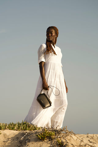 Model on the beach wearing Coneli Fanny Pack Black as shoulder bag